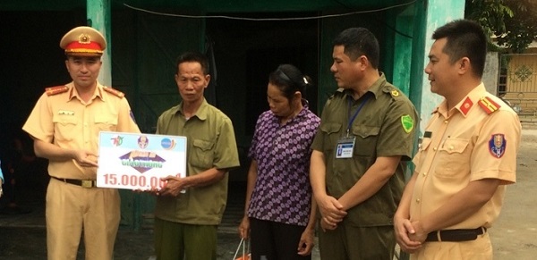 Đại diện Phòng Cảnh sát giao thông Công an tỉnh và Công ty TNHH Long Hải trao quà cho ông Đoàn Văn Thất ở thôn Hoàng Tường, xã Tân Trào.