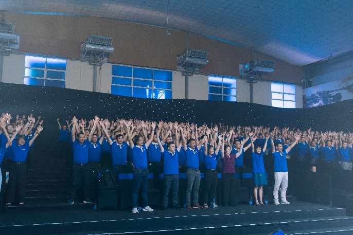 A group of people in blue shirts

Description automatically generated