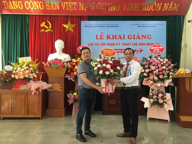 Lãnh đạo nhà trường Cao đẳng Kỹ thuật Công nghệ Hòa Bình tặng hoa chúc mừng tại buổi Lễ khai giảng năm học - Ảnh: Phi Long