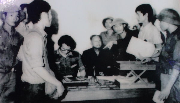Đại úy Phạm Xuân Thệ (ngoài cùng bìa phải) trên tay đang cầm bản thảo