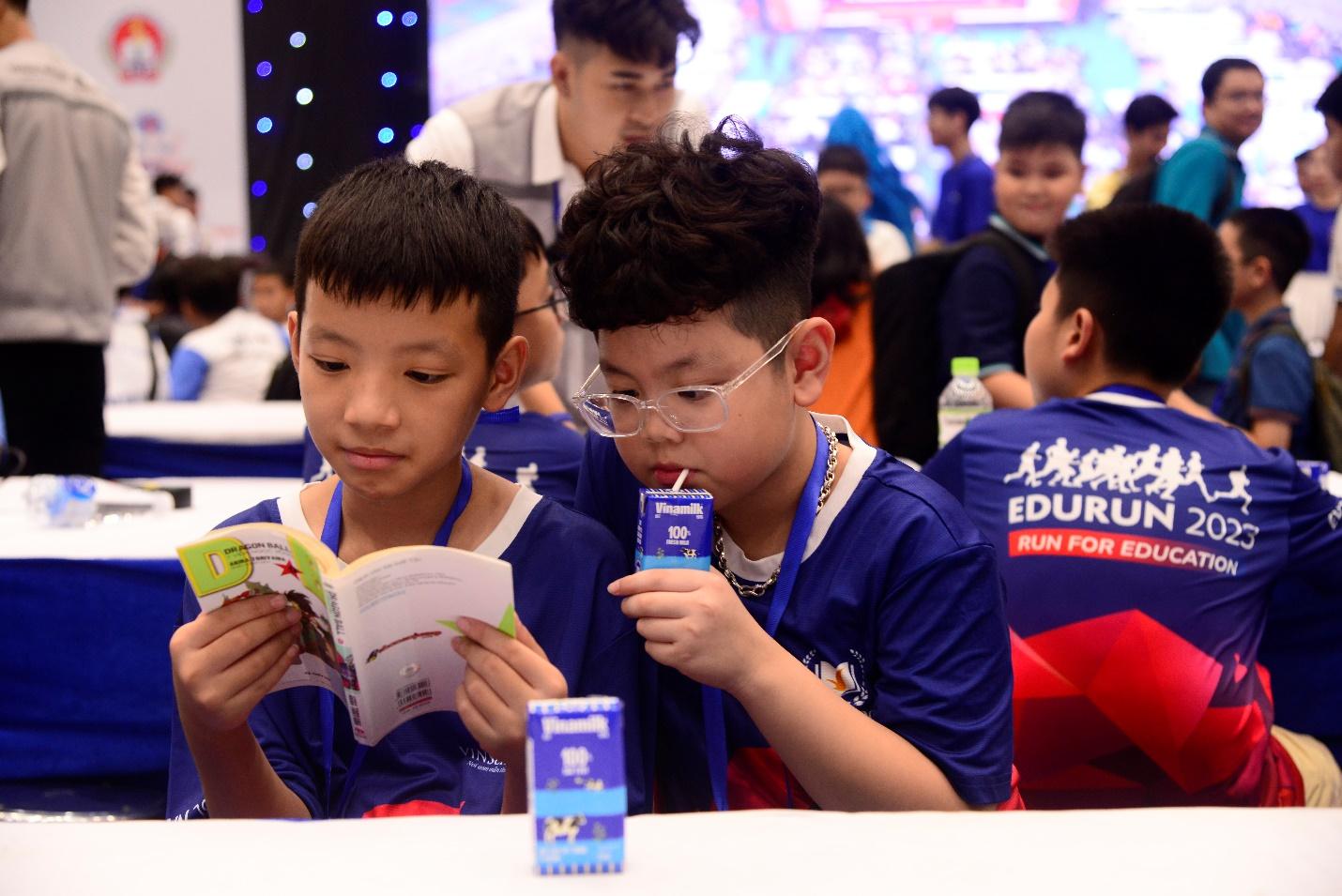 A group of boys sitting at a table reading a book

Description automatically generated