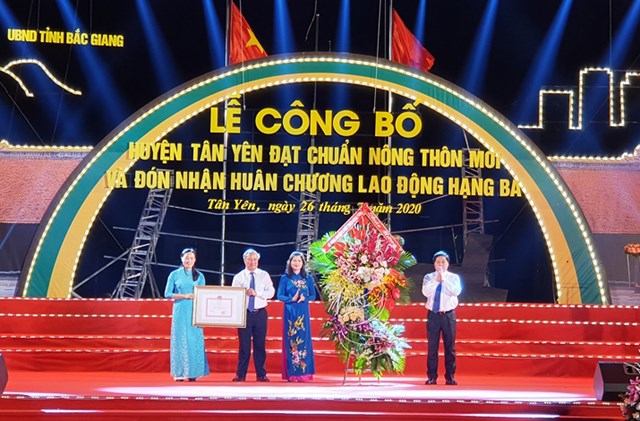 Thừa ủy quyền của Thủ tướng Chính phủ, đồng chí Lê Quốc Doanh - Thứ trưởng Bộ Nông nghiệp và PTNTtrao Bằng công nhận đạt chuẩn NTM cho huyện Tân Yên