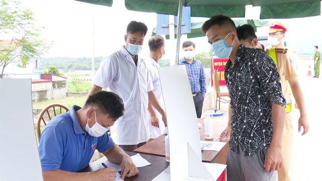 Người dân thực hiện khai báo y tế khi đi qua chốt kiểm soát dịch Covid-19 điểm cầu Đồng Quang.