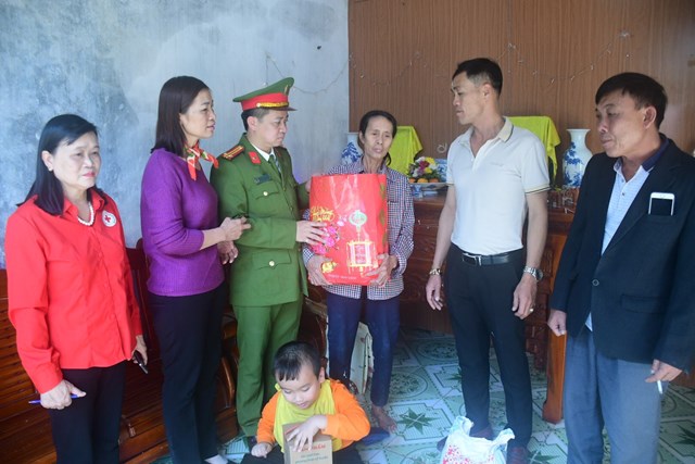 Đồng chí Trung tá Lê Quang Hoà cùng lãnh đạo địa phương và DN đóng trên địa bàn trao tặng quà Tết cho Bà Bùi Thị Loan.