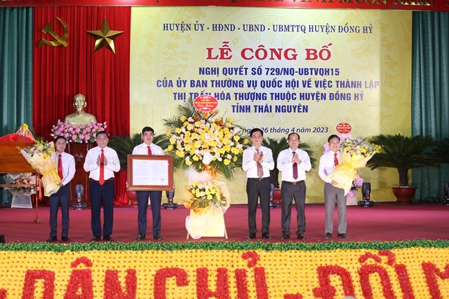 Lãnh đạo huyện Đồng Hỷ đón nhận Nghị quyết và hoa chúc mừng của Ủy ban Thường vụ Quốc hội về việc thành lập thị trấn Hóa Thượng. Ảnh: Phi Long.