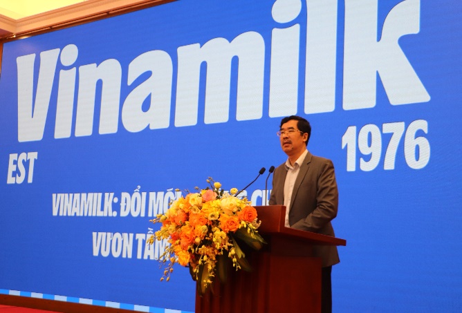 A person standing at a podium with flowers

AI-generated content may be incorrect.