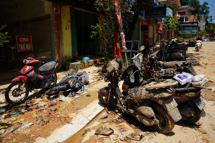 A group of motorcycles and cars on a street

Description automatically generated