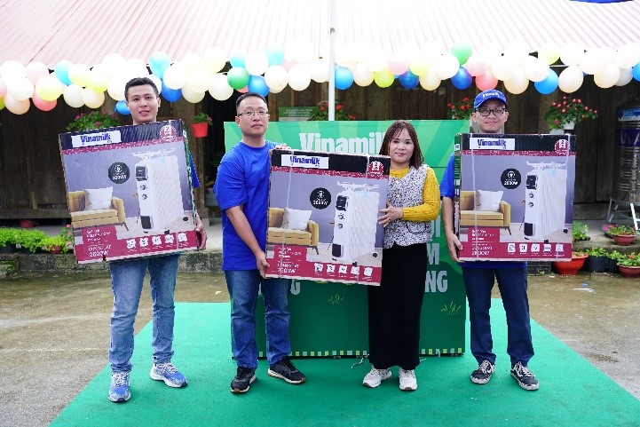 A group of people holding up cardboard boxes

Description automatically generated