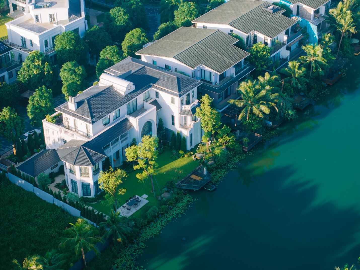 A large white house next to a body of water

Description automatically generated