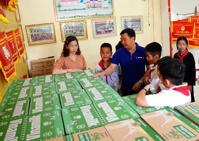 A group of people looking at a table with boxes

Description automatically generated