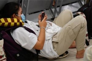 Khách nằm, ngồi giữa sàn đợi lên máy bay tại Cảng hàng không Nội Bài
