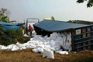 Hà Nội: Container lật ngang, hàng trăm tấn gạo đổ xuống đường