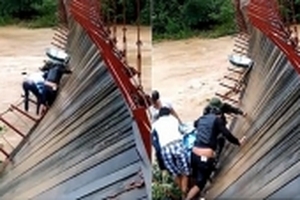 Cầu treo đứt dây cáp, người và xe lơ lửng trên dòng nước lũ