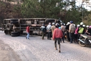 Xe tải bị lật, tài xế mắc kẹt trong cabin chờ giải cứu