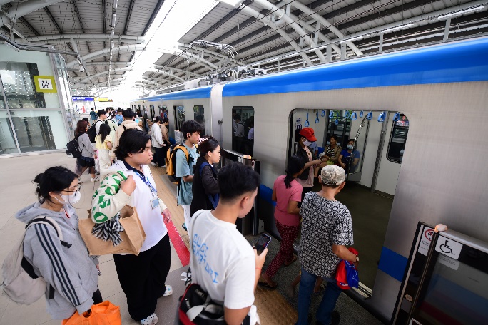 A group of people standing in a train station

Description automatically generated