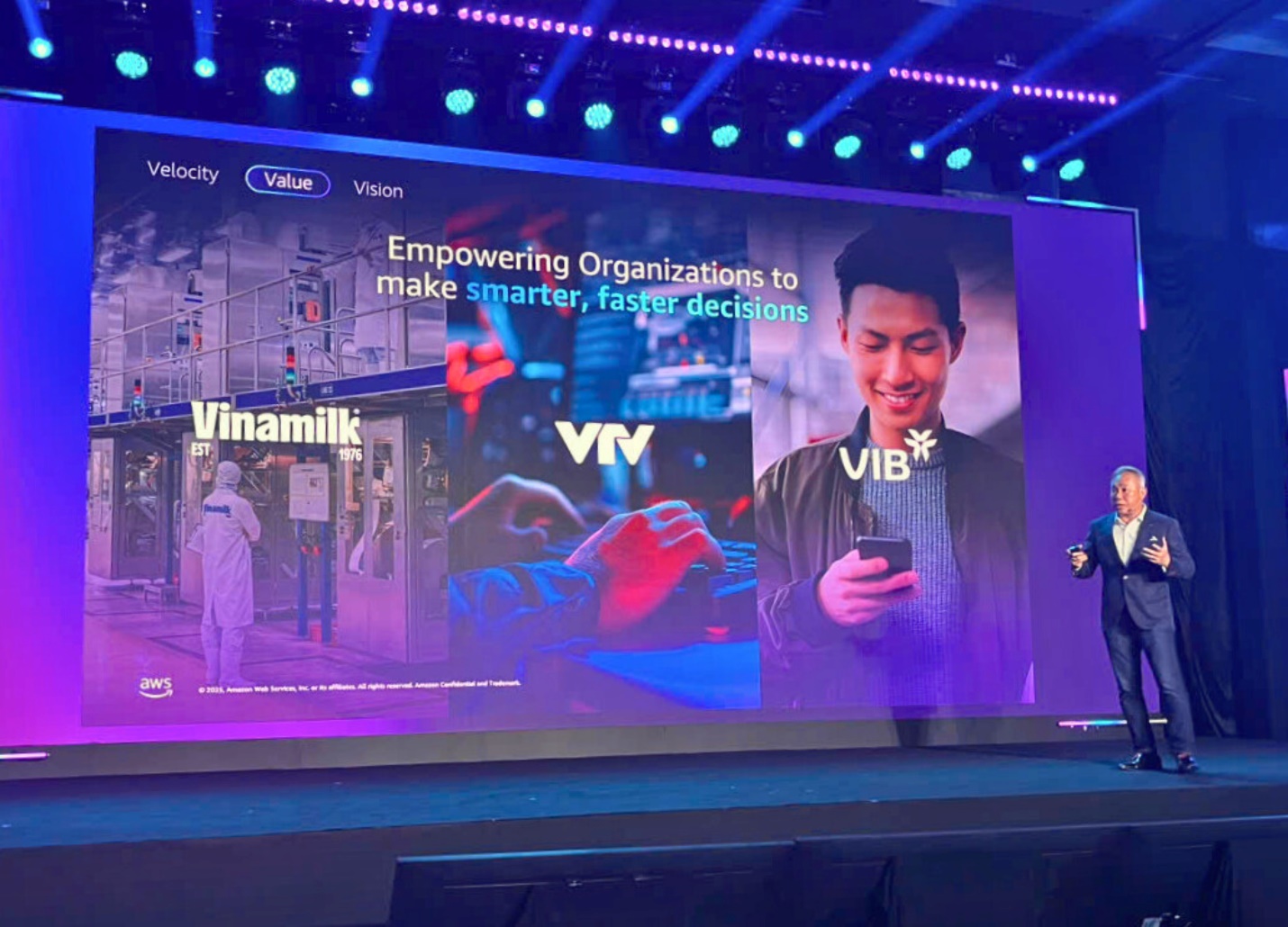 A person standing on a stage with a large screen

AI-generated content may be incorrect.