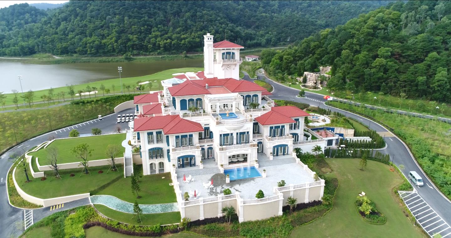 A large white house with a pool in front of it

Description automatically generated