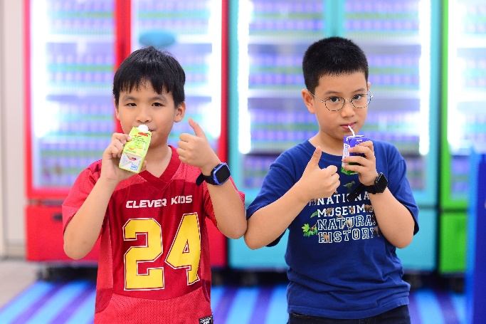 Two boys drinking from a juice bottle

Description automatically generated