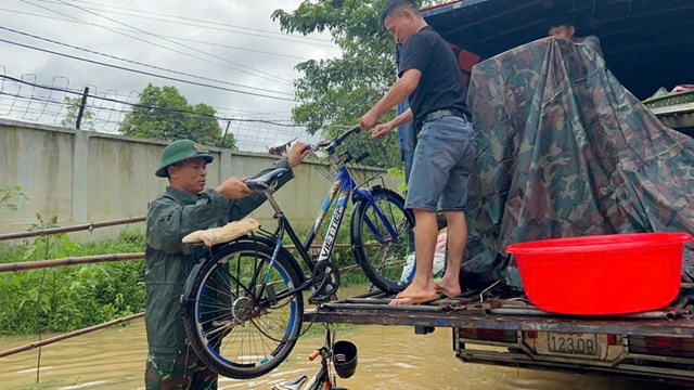 Giúp bà con di rời tài sản ra khỏi vùng ngập lụt.  