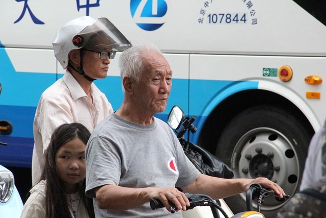 Ông Wang Ming – cư dân thành phố Hàng Châu dừng xe tại ngã tư, chờ tín hiệu đèn giao thông (Ảnh Quốc Khánh)