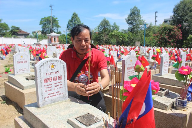 Ông Nguyễn Hồng Kỳ – Phó Chủ tịch Thường trực Liên hiệp các Tổ chức hữu nghị tỉnh Nghệ An – lặng lẽ bên phần mộ liệt sĩ Nguyễn Văn Thái, chú ruột của mình. (Ảnh: Quốc Khánh)
