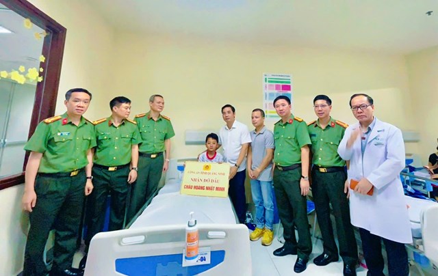 Thiếu tướng Trần Văn Phúc - Ủy viên Ban Thường vụ Tỉnh ủy, Bí thư Đảng ủy, Giám đốc Công an tỉnh (áo trắng, bên phải cạnh cháu bé) cùng tập thể lãnh đạo các phòng nghiệp vụ trao số tiền hỗ trợ 200 triệu đồng và nhận đỡ đầu cháu Hoàng Nhật Minh.
