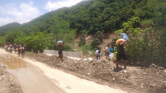 Người d&acirc;n x&atilde; Mường T&iacute;p khẩn trương vận chuyển h&agrave;ng h&oacute;a vượt s&ocirc;ng Nậm Mộ để kịp thời hỗ trợ b&agrave; con bản Na Meuang (L&agrave;o) đang bị c&ocirc; lập do mưa lũ.