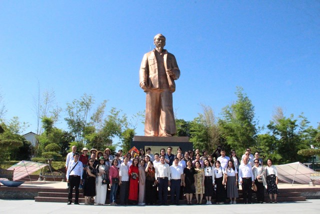Các đại biểu chụp ảnh lưu niệm dưới chân tượng đài Bác Hồ về thăm quê.