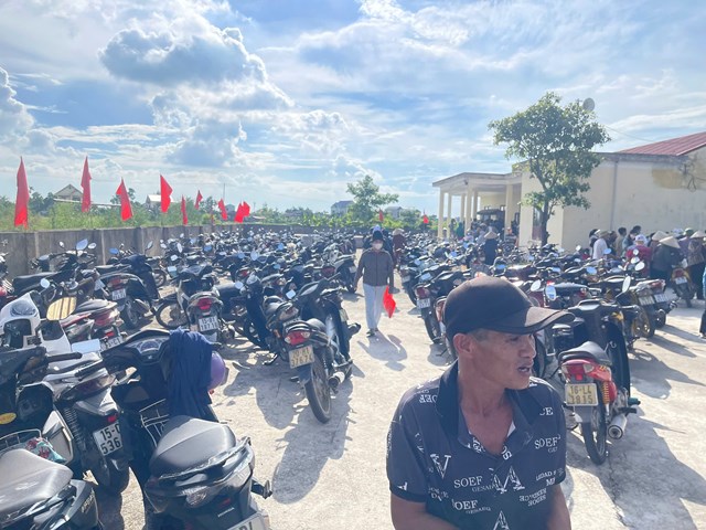Sân nhà văn hóa rợp cờ đỏ, xe máy của nhân dân tập trung về dự ngày chi trả