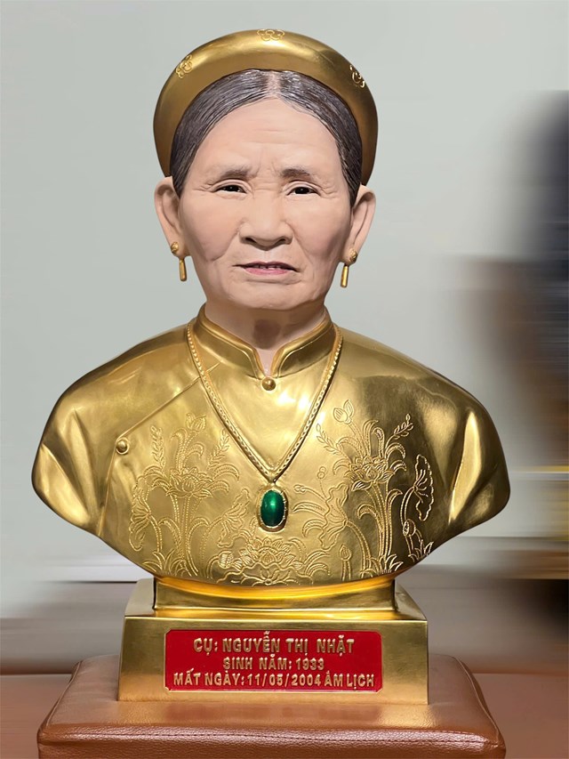 Tượng chân dung cụ Nguyễn Thị Nhặt bằng đồng dát vàng, chạm khắc hoa văn trên áo dài tinh tế, tôn vinh phẩm hạnh người phụ nữ Việt.