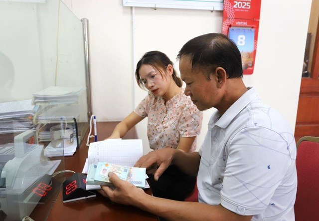 Cán bộ Phòng Giao dịch Ngân hàng Chính sách xã hội Vĩnh Tường hướng dẫn ông Lã Văn Mạnh, xã Vĩnh Phú, hoàn tất thủ tục vay vốn và nhận tiền theo chương trình tín dụng dành cho sinh viên học ngành STEM.