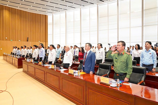 C&aacute;c đại biểu HĐND th&agrave;nh phố thực hiện nghi thức ch&agrave;o cờ tại phi&ecirc;n họp.