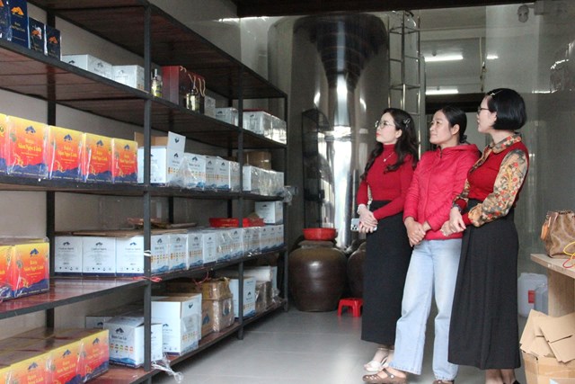 Chị Nguyễn Thị Mai (giữa) dẫn kh&aacute;ch tham quan gian trưng b&agrave;y sản phẩm tại C&ocirc;ng ty