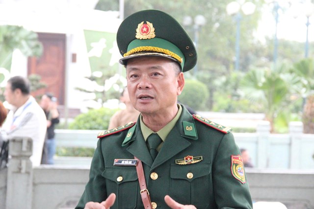 Thượng t&aacute; B&ugrave;i Tuấn Anh, Bộ đội Bi&ecirc;n ph&ograve;ng Cửa khẩu Quốc tế M&oacute;ng C&aacute;i trao đổi th&ocirc;ng tin với c&aacute;c đại biểu tại Cột mốc 1369.