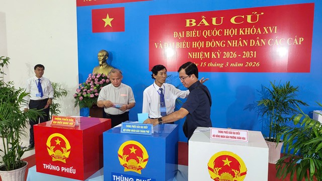 C&aacute;n bộ tại điểm bầu cử hướng dẫn cử tri thực hiện c&aacute;c thủ tục bỏ phiếu