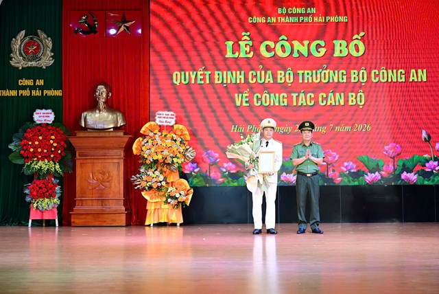 Đồng ch&iacute; B&ugrave;i Quang B&igrave;nh, Gi&aacute;m đốc C&ocirc;ng an TP Hải Ph&ograve;ng trao quyết định v&agrave; tặng hoa ch&uacute;c mừng Đại t&aacute; Nguyễn B&igrave;nh Kh&aacute;nh.